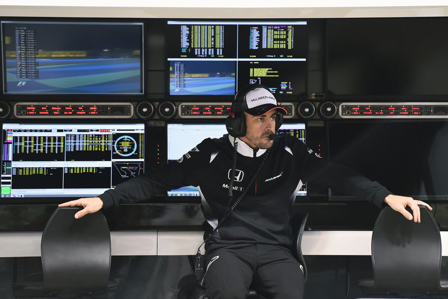 Fernando Alonso sits in the pit wall