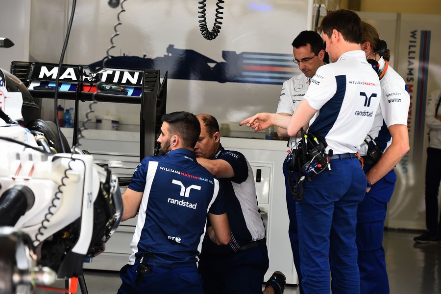 Rob Smedley and Williams mechanics look at Felipe Massa's FW38 in the garage following the punctures in FP1