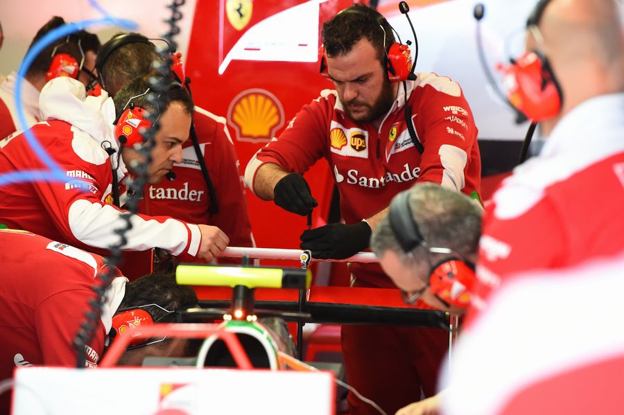 Ferrari mechanics work on rear wing of Kimi Raikkonen's Ferrari