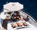 Girls tan themselves on a yacht in the harbour