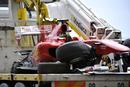 Fernando Alonso's crashed Ferrari is driven away on a lorry