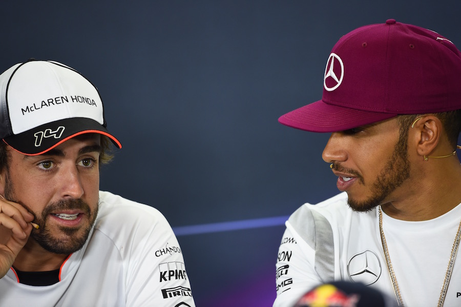 Fernando Alonso talks with Lewis Hamilton during the press conference