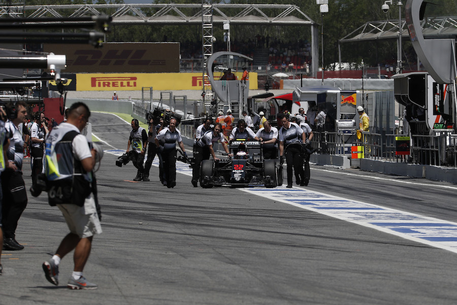 Jenson Button is pushed by the McLaren crews after stopping in pit lane