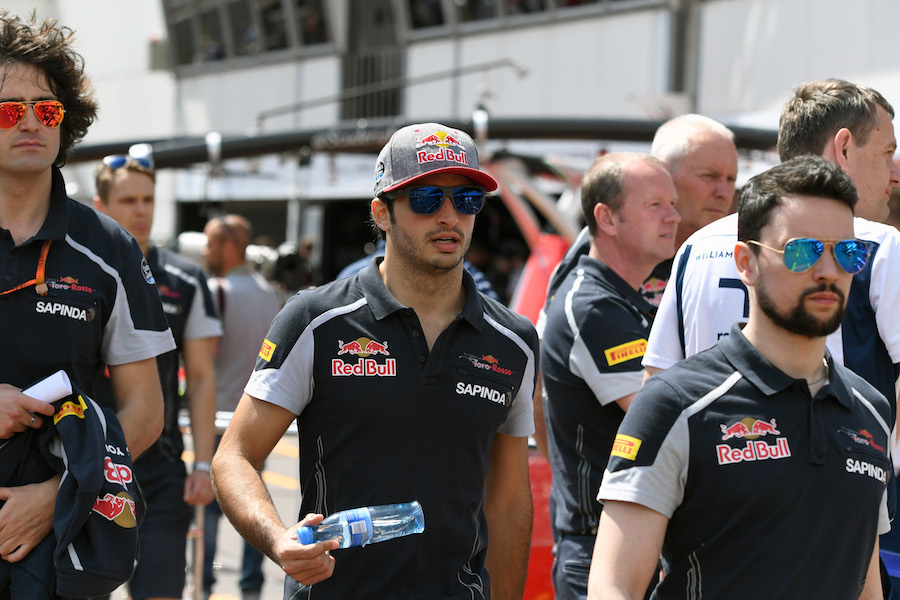 Carlos Sainz walks through the paddock with engineers