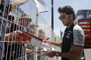 Sergio Perez signs an autograph for fans