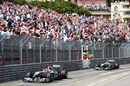 Michael Schumacher waves to the crowd followed by team-mate Nico Rosberg at the finish