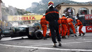 Stewards clear the crashed cars of Jarno Trulli's Lotus and Karun Chandhok's HRT