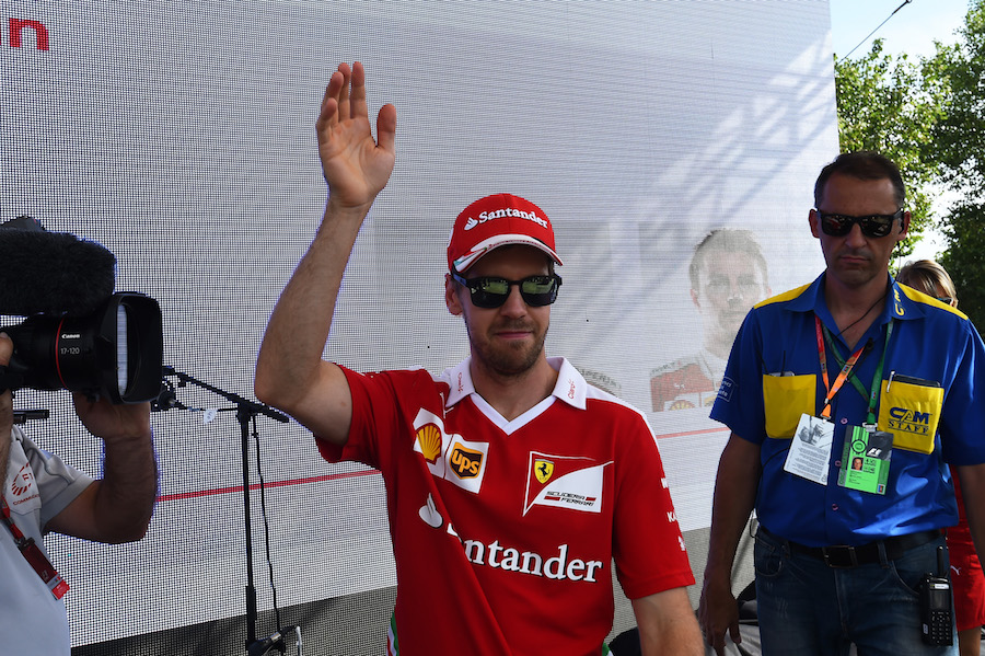 Sebastian Vettel waves to fans at the autograph session