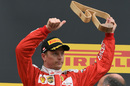 Kimi Raikkonen celebrates with the trophy on the podium