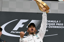 Lewis Hamilton celebrates with the trophy on the podium