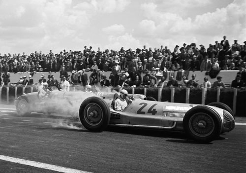 Rudolf Caracciola lights up the rear tyres of his Mercedes W154 off the line