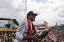 Lewis Hamilton celebrates with the fans and the champagne