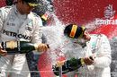 Lewis Hamilton and Nico Rosberg celebrate on the podium with the champagne