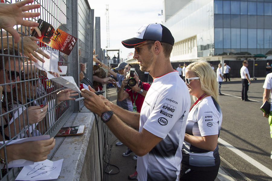 Jenson Button signs autographs for the fans