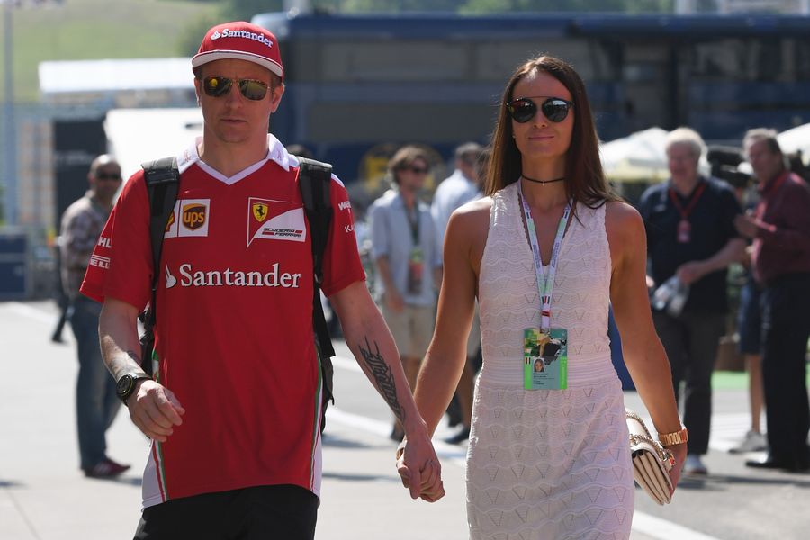 Kimi Raikkonen walks through the paddock with his wife Minttu Virtanen