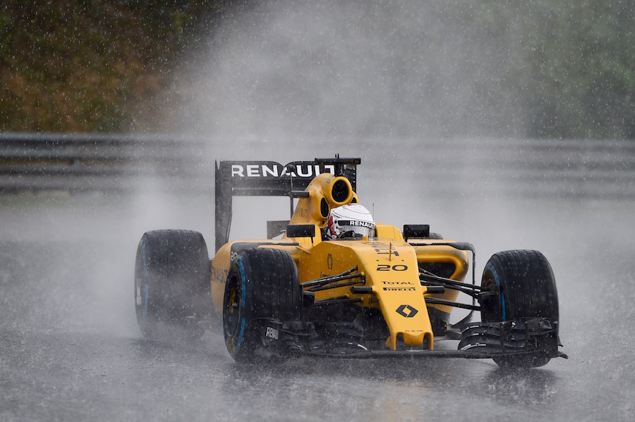 Kevin Magnussen drives through the spray heavily