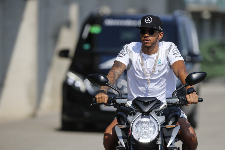 Lewis Hamilton arrives at the track on a motorbike