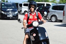 Sebastian Vettel arrives on a scooter