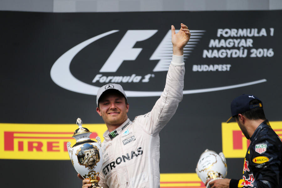 Nico Rosberg celebrates on the podium with the trophy