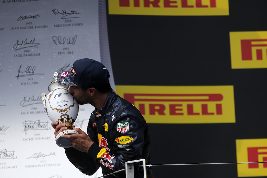 Daniel Ricciardo kisses the trophy on the podium