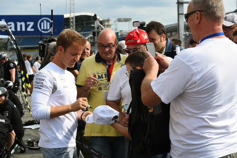 Nico Rosberg signs autographs for a fan