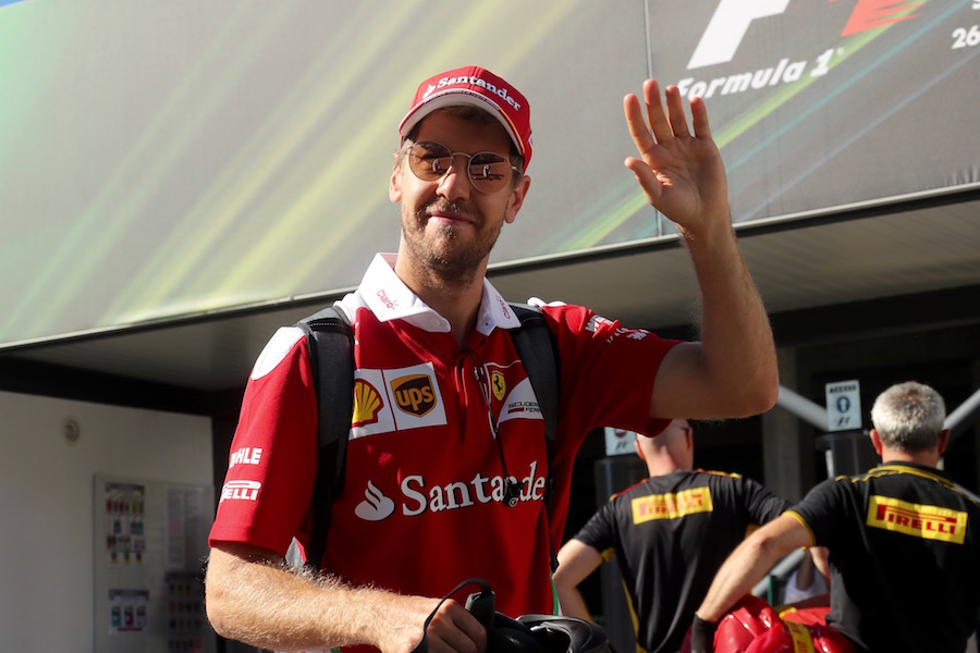 Sebastian Vettel waves a hand with smiling