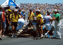 Nigel Mansell collapses after pushing his Lotus after it came to a halt at the US GP