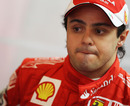 Felipe Massa keeps an eye on his mechanics in the Ferrari garage