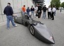 Fans look over a Delta Wing concept car in the pagoda plaza during practice for the Indianapolis 500