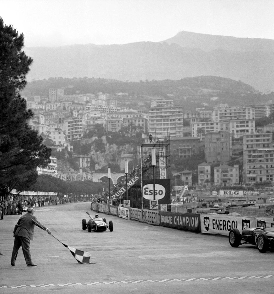 Stirling Moss in a Lotus 18 crosses the finish line