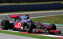 Jenson Button leans on the kerb in his McLaren