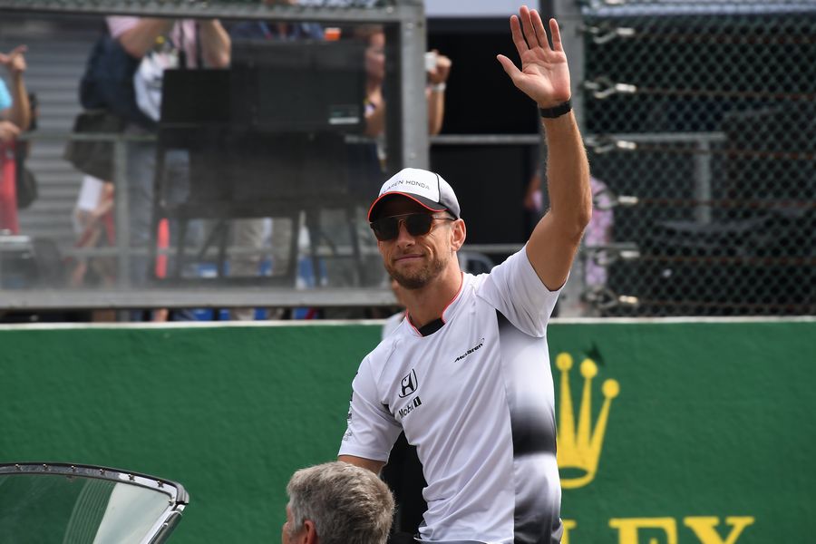 Jenson Button waves to fans on the drivers parade