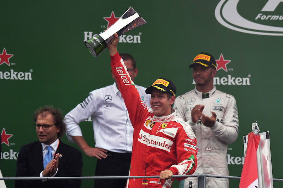 Sebastian Vettel celebrates on the podium with the trophy