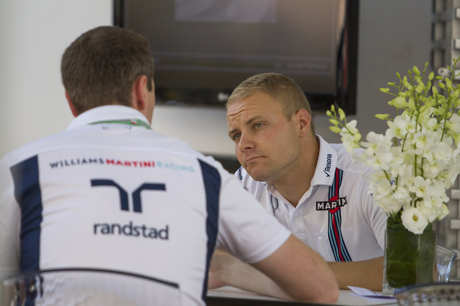 Valtteri Bottas discusses something at the paddock