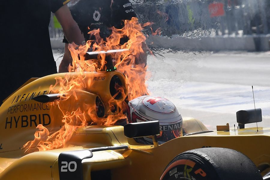 Kevin Magnussen in his on fire Renault after returning to the pit