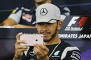 Lewis Hamilton takes a photograph on his iPhone