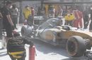 The burnt car of Kevin Magnussen in the pit lane