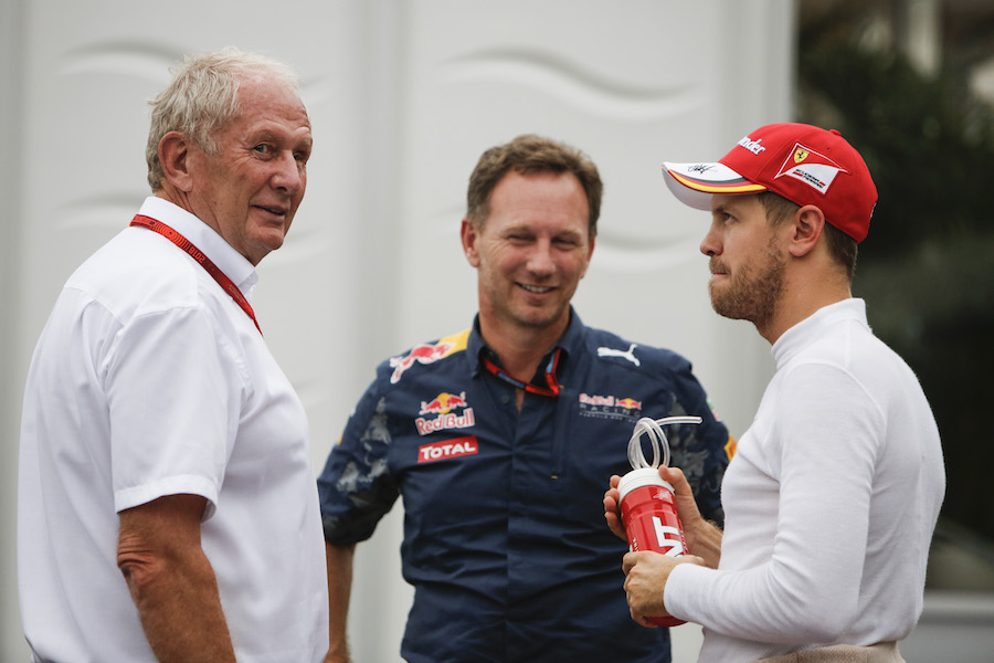 Helmut Marko, Christian Horner and Sebastian Vettel talk in the paddock