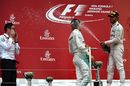 Andy Shovlin, Nico Rosberg and Lewis Hamilton celebrates on the podium with the champagne