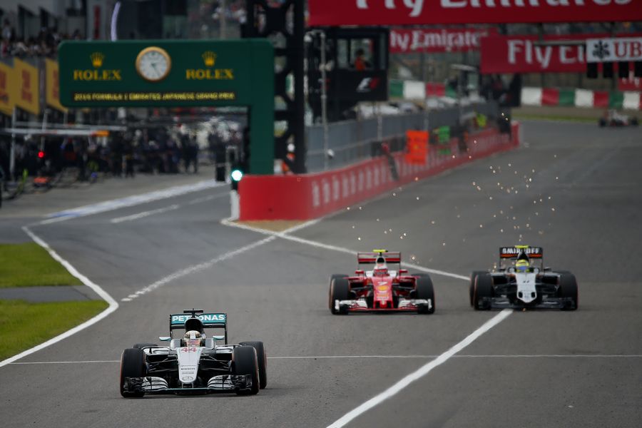 Lewis Hamilton exits the pits while Kimi Raikkonen  passes Sergio Perez