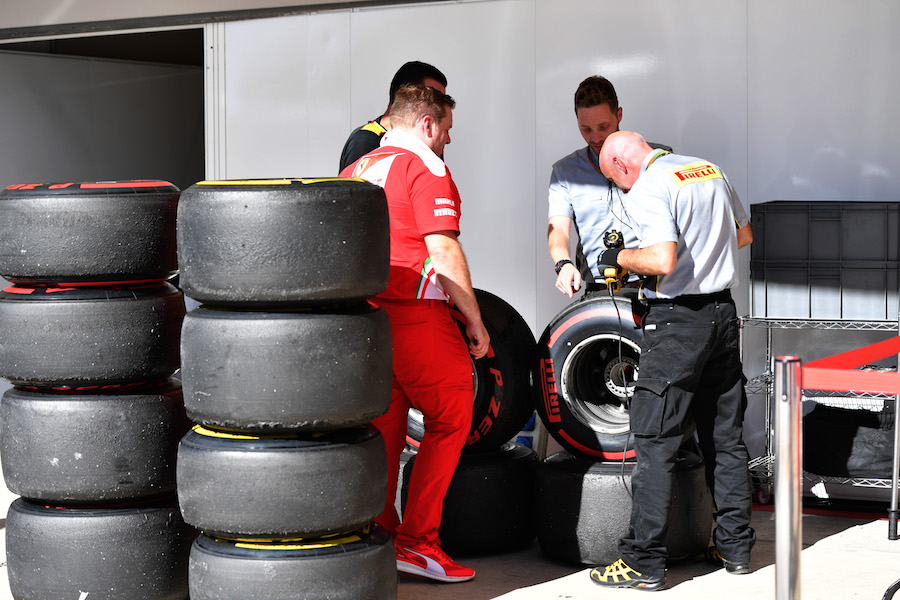 Ferrari mechanic and Pirelli technicians check tyres