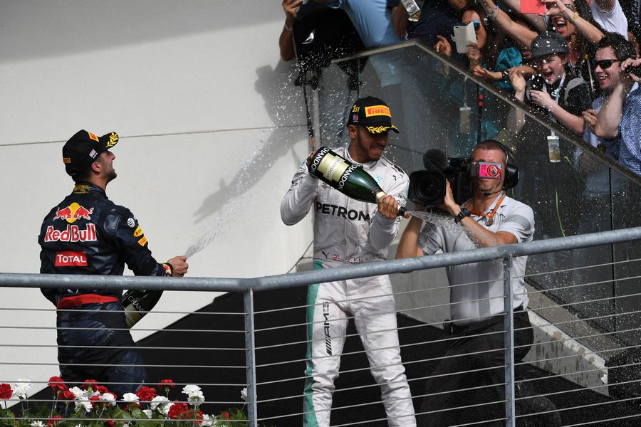 Lewis Hamilton and Daniel Ricciardo celebrate on the podium with the champagne