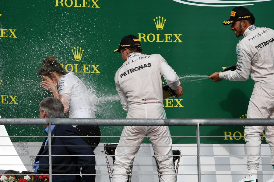 Nico Rosberg and Lewis Hamilton celebrate on the podium with Victoria Vowles