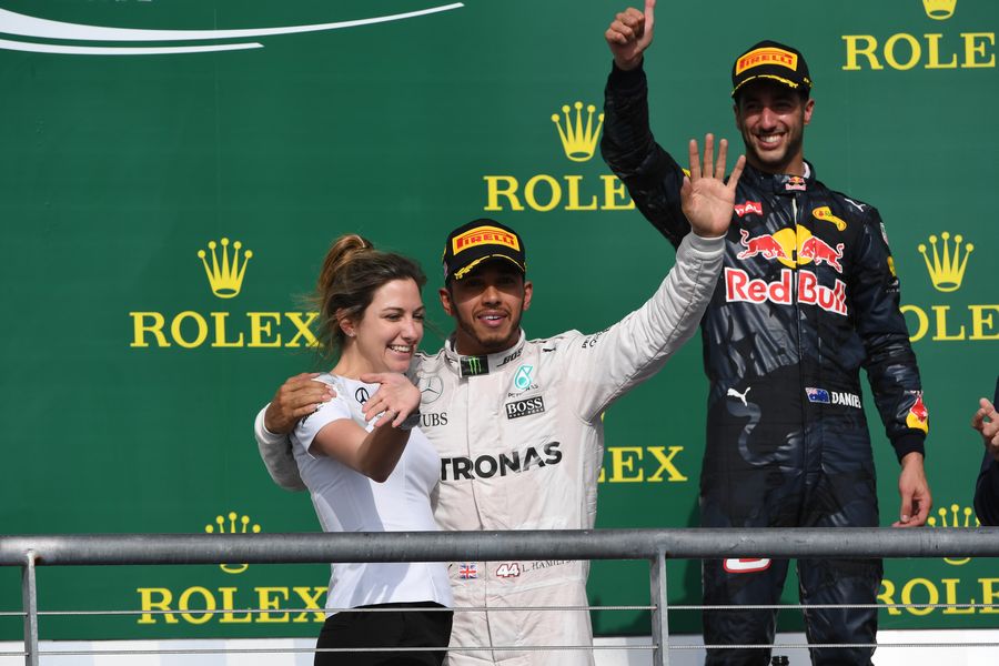 Lewis Hamilton celebrates on the podium with Victoria Vowles