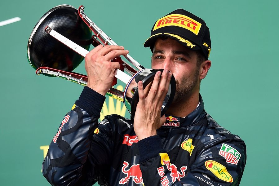 Daniel Ricciardo celebrates on the podium with the trophy