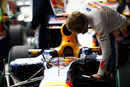 Sebastian Vettel checks his Red Bull for damage 