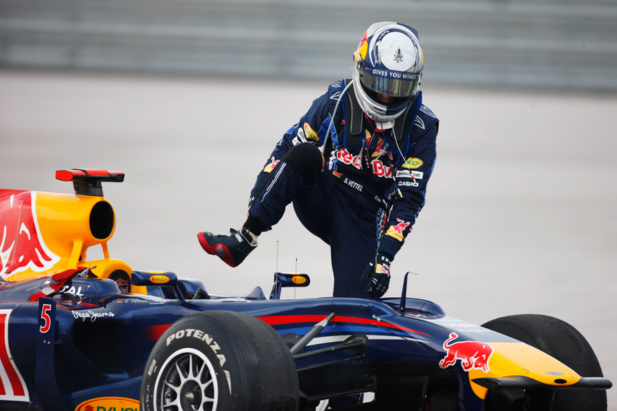 Sebastian Vettel climbs out his car after his collision with Mark Webber