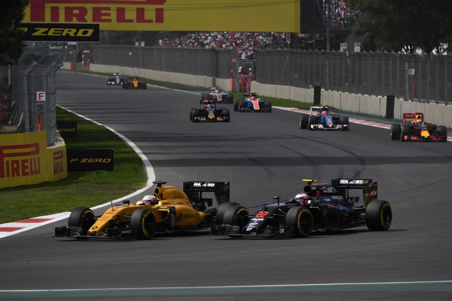 Kevin Magnussen fights a position with Jenson Button