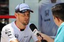 Jenson Button speaks to media at the paddock