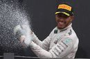 Lewis Hamilton celebrates on the podium with the chmpagne
